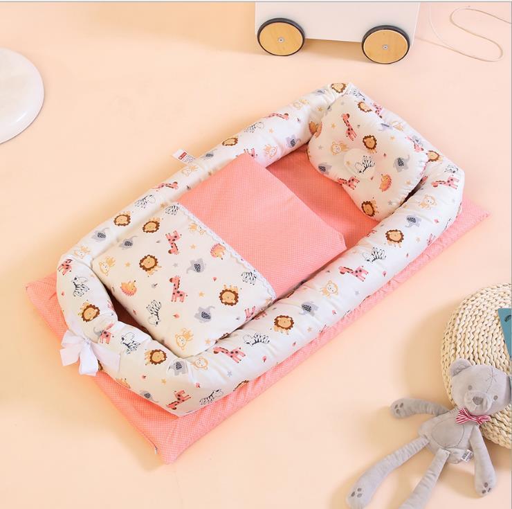 Côte & Crown foldable middle bed for newborn infants with animal print and pink bedding