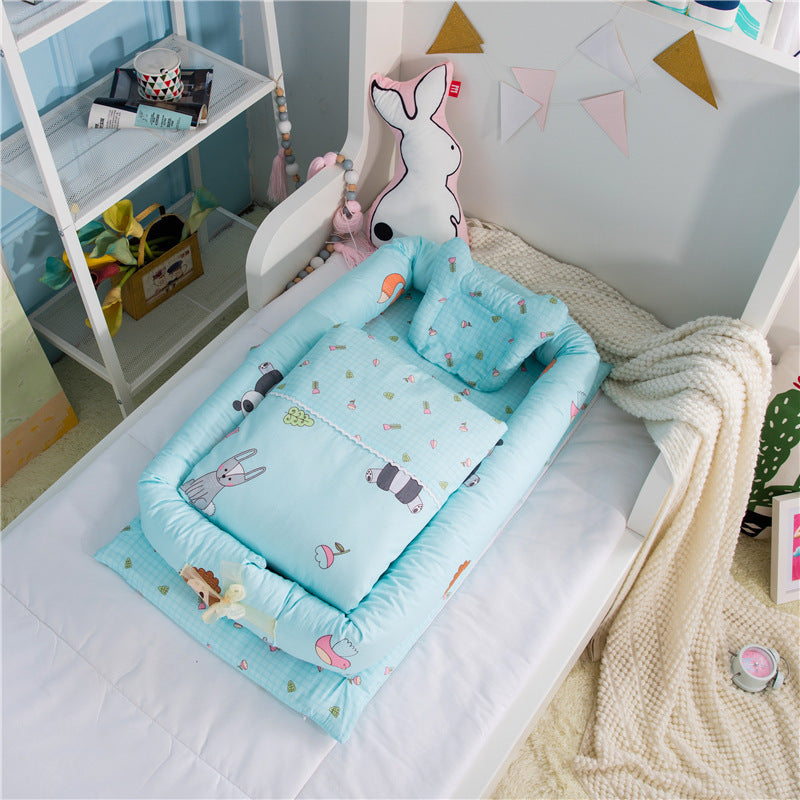 New-born foldable middle bed baby infant in blue with animal prints by Côte & Crown placed on a white bed