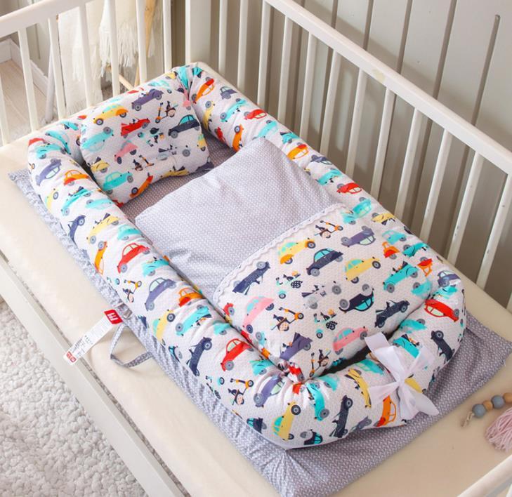 Foldable newborn middle bed baby infant with colorful car print from Côte & Crown in a white crib