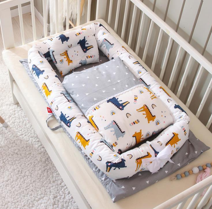 Foldable newborn middle bed baby infant with colorful dinosaur print by Côte & Crown in white and gray