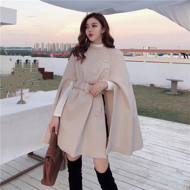 Womens beige cape coat with belted waist and button detail by Côte & Crown styled with black boots