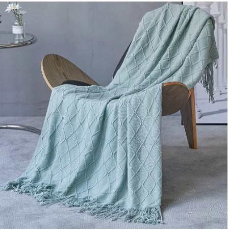 LEDSone affordable luxury throw blanket in soft green draped over a stylish chair