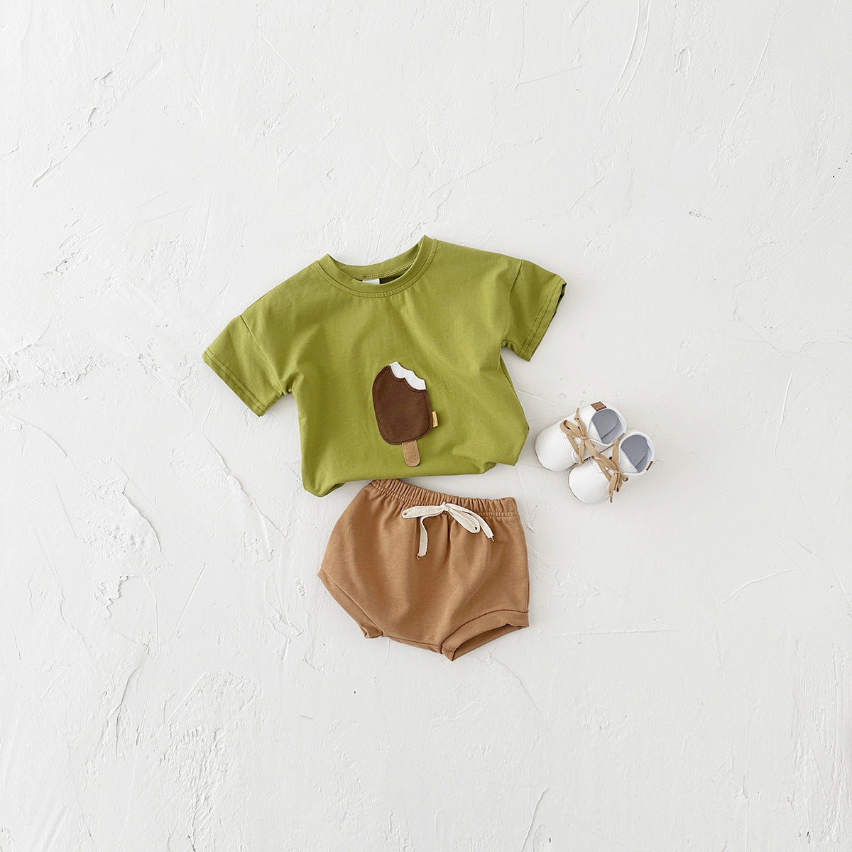 Côte & Crown baby clothes set with green ice cream graphic t-shirt and brown shorts with white baby shoes