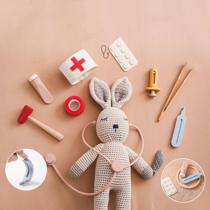 Côte & Crown children's doctor play set with crocheted bunny and various medical toy tools on beige background