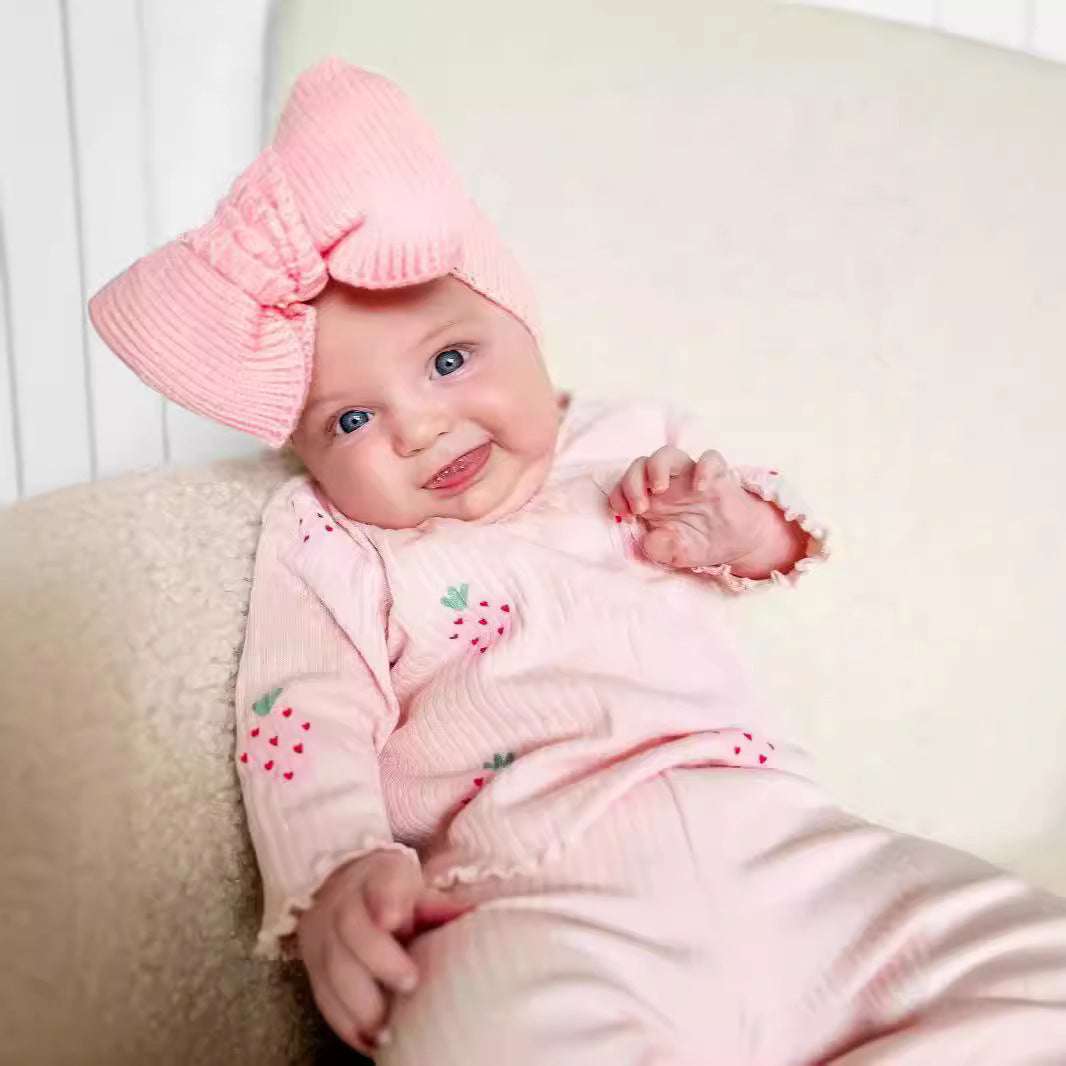 Infant wearing Côte & Crown baby girl strawberry infant printed 3 piece outfit with pink bow headband
