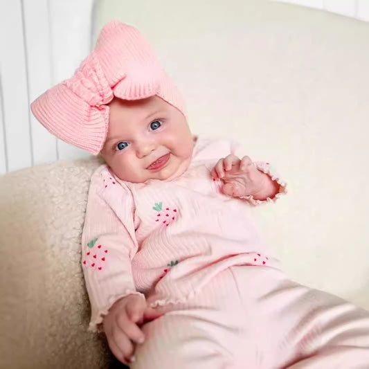 Infant wearing Côte & Crown baby girl strawberry infant printed 3 piece outfit with pink bow headband