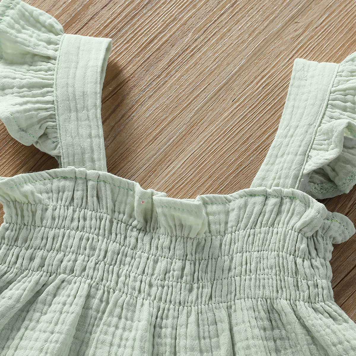Close-up of mint green girls summer sling top and shorts set by Côte & Crown with textured fabric