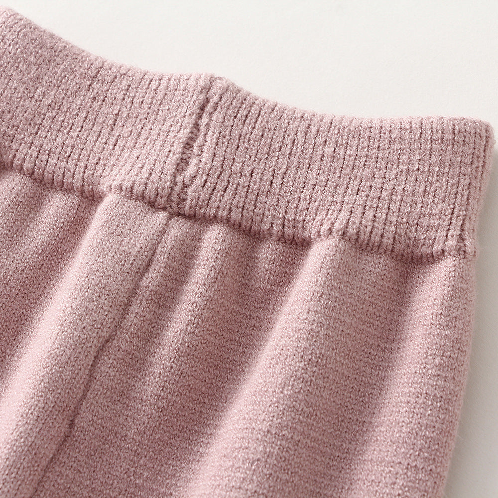 Close-up of soft pink children's knitted sweater set waistband showing ribbed knit texture