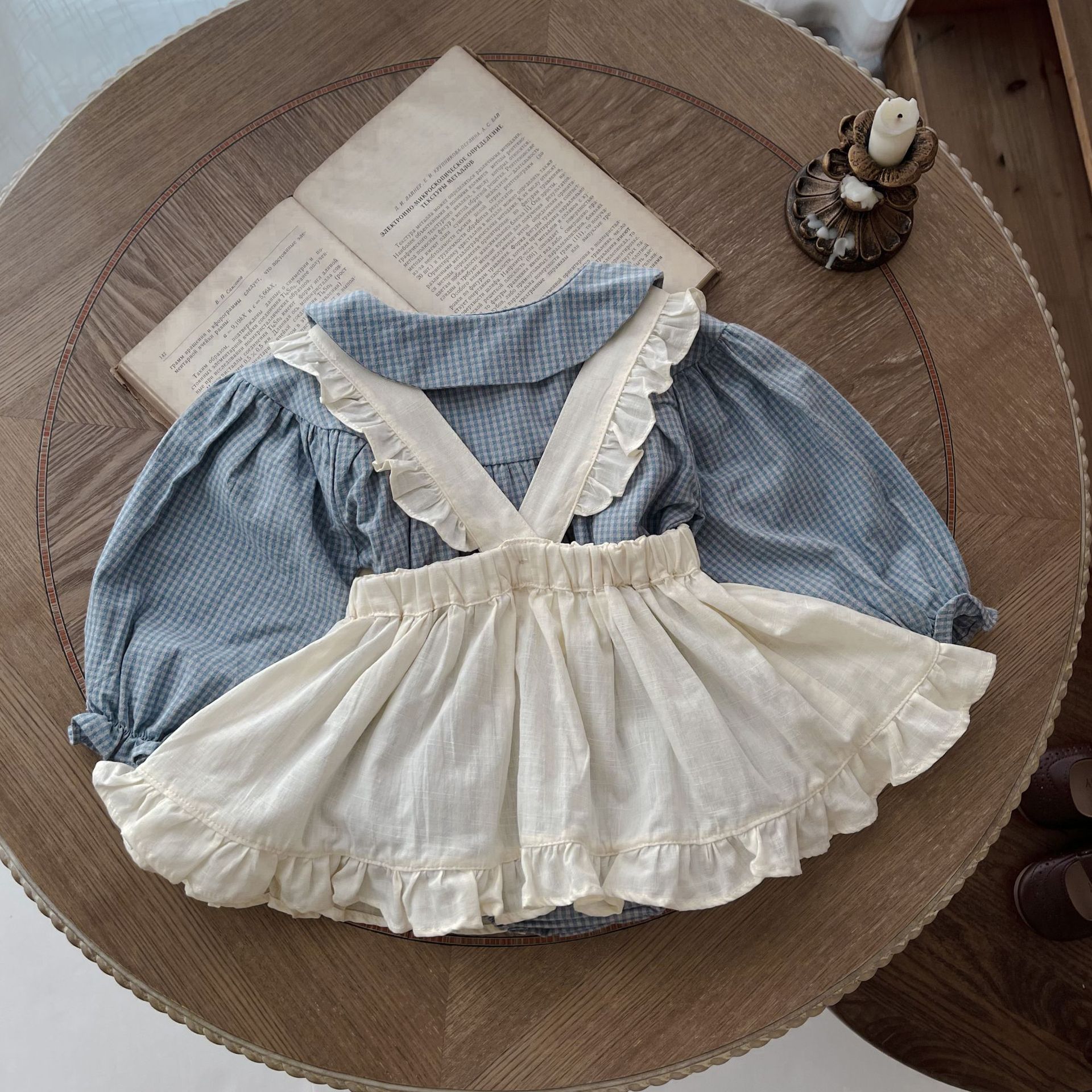 Côte & Crown ruffled baby romper dress with blue checkered top and cream ruffled skirt overlay