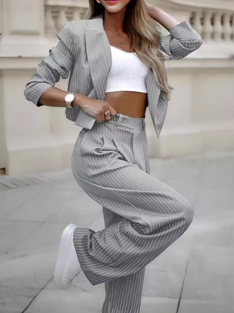 women's office outfit featuring a grey striped blazer and matching trousers with a white crop top